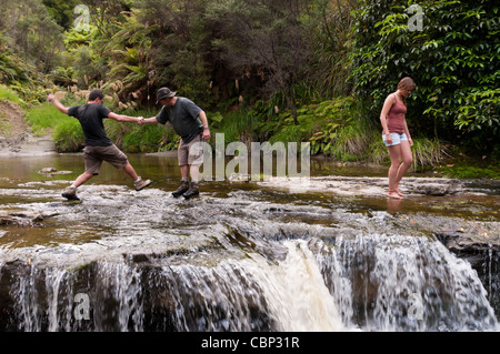 Gruppe junger Menschen im dort zwanzig Kreuzung River an der Spitze der Waterwall mit Führer, die Hand zu geben Stockfoto