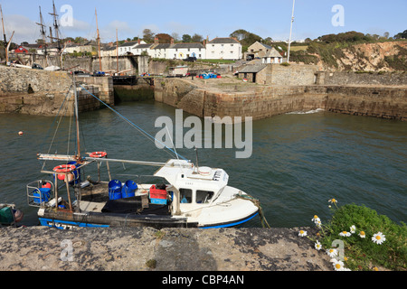 Angelboot/Fischerboot in der Außenhafen mit weißen Häuschen am Kai. Charlestown, Cornwall, England, Vereinigtes Königreich, Großbritannien. Stockfoto