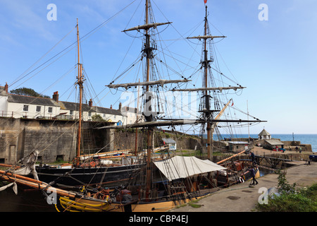 Pheonix und andere Großsegler im inneren Hafen mit alten Hütten auf der Uferstraße. Charlestown, Cornwall, England, Großbritannien, Großbritannien Stockfoto