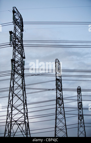 Hochspannungsleitungen, die aus einem Kohle abgefeuert Kraftwerk um eine Aluminiumschmelze in Ashington, Nord-Ost, UK. Stockfoto