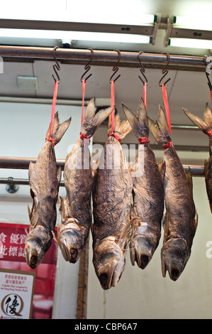 Westlicher Bezirk auf Hong Kong Island hat noch viele traditionelle Geschäfte und Straßen. Fische trocknen hinter Ampel. Stockfoto