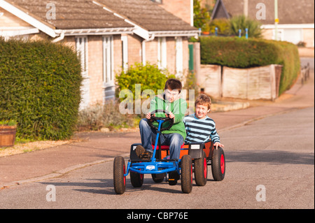 Zwei Jungs spielen auf einem Berg go Karts mit Anhänger in einer Uk-Straße Stockfoto