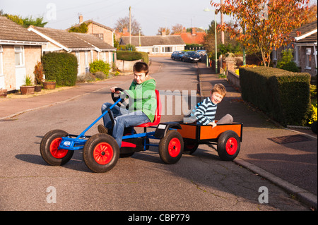 Zwei Jungs spielen auf einem Berg go Karts mit Anhänger in einer Uk-Straße Stockfoto