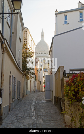 Eine Gasse in der malerischen Gegend von Montmartre, Paris, mit der Kirche Sacre-Coeur im Hintergrund Stockfoto