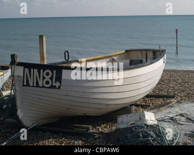 Kleines Boot zum Angeln im Meer eingesetzt, zog hoch auf einem steinigen Strand mit Netzen und anderen Utensilien am Strand an der Südküste von England festgelegt Stockfoto