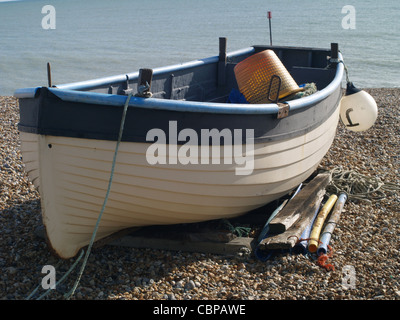 Kleines Boot für den Fischfang, festgemacht an einem steinigen Strand in Süd-Ost-England eingesetzt Stockfoto