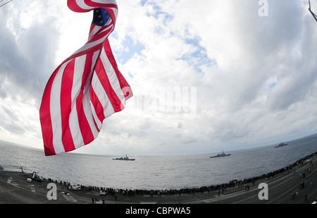 ATLANTISCHER OZEAN (Dez 9, 2011) die Lenkraketen-Kreuzer USS Anzio (CG 68), rechts, die Lenkraketen-Zerstörer USS Mitscher (DDG 57) und USS Truxtun (DDG 103) befinden sich neben dem Flugzeugträger USS George H.W. in Formation Bush (CVN 77) während einer Seestraft-Demonstration. George H.W. Bush beherbergt mehr als 1,200 Freunde und Familienmitglieder der Crew als Teil einer Tiger Cruise am Ende des ersten Kampfeinsatzes von shipÕs. Stockfoto