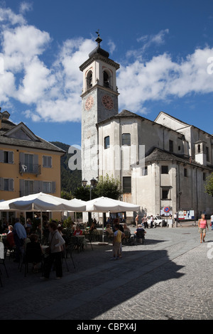 Glockenturm der Kirche mit Café und Straßenszene auf der Piazza in Comune di Santa Maria Maggiore, Piemont, Valle Ossola, Italien. Stockfoto