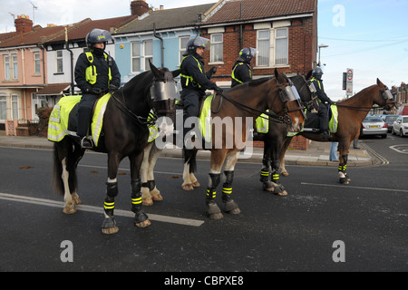 Berittene Polizei Offiziere und Pferde in schützende Riot Kleid blockieren eine Straße während ein Fußball-Spiel-Gruppenkontrolle. Portsmouth Hants Stockfoto