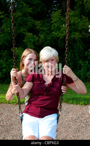 Midwest-Mutter und Tochter spielen im Park im Swing und umarmt spielen Stockfoto