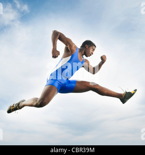 Afrikanische amerikanische Athleten springen in der Luft Stockfoto