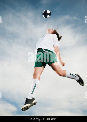 Kaukasische Teenager Überschrift Fußball Ball in der Luft Stockfoto