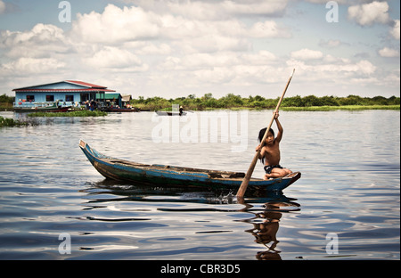 Ein junges Mädchen Paddel ein kleines Boot durch das Wasser auf dem Fluss Sangker zwischen Siem reap und Battambang in Kambodscha Stockfoto