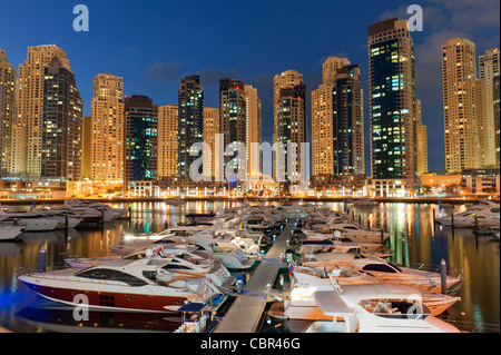 Boote am Abend im Yachtclub Marina mit Apartment-Türme in New Dubai in Vereinigte Arabische Emirate nach hinten Stockfoto