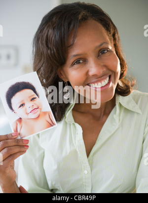 Schwarze Frau mit Foto von baby Stockfoto