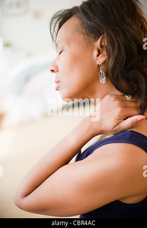 Schwarze Frau, die ihren Hals reiben Stockfoto