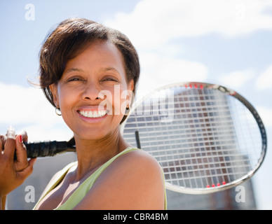 Schwarze Frau mit Tennisschläger Stockfoto