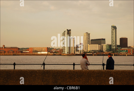 Fischer auf den Fluss Mersey, Birkenhead, Wirral, UK. Im Hintergrund ist Liverpools skyline Stockfoto