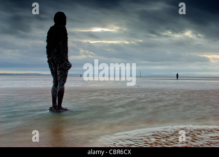 Antony Gormley ist ein weiterer Ort Kunstinstallation. 100 Ironmen säumen den Strand für eine Meile auf Crosby, Merseyside, UK Stockfoto