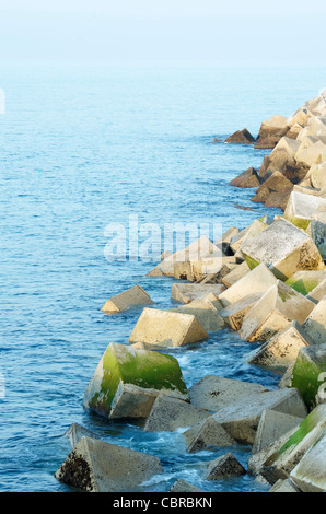 Wellenbrecher gebaut mit Betonsteinen am Hafen von Llanes, Asturien, Spanien Stockfoto