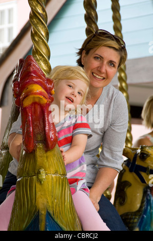 Vertikale nahe Porträt einer Mutter und Tochter auf einem Rummelplatz-Karussell. Stockfoto