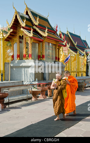 Zwei buddhistische Mönche mit geschlossenen Augen & Haende im Gebet herumlaufen Stupa in einem buddhistischen Tempel in Thailand Lamphun Stockfoto