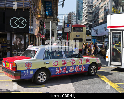 Dh Mong Kok HONG KONG Rot Taxi mit Kalligraphie Anzeige in überfüllten Verkehr Straße Menschen Stockfoto