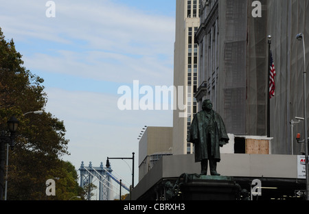 Herbstliche Ansicht in Richtung grau Nickel Gitterturm Manhattan Bridge, Bronzestatue Beecher, Columbus Plaza, Brooklyn, NY Stockfoto