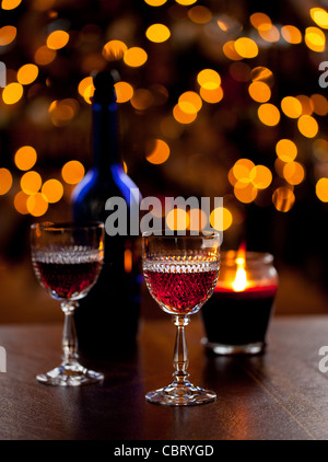 Schneiden Sie Glas Sherry oder Portwein Gläser vor einer Fokus-Weihnachtsbaum mit blauen Flasche Stockfoto