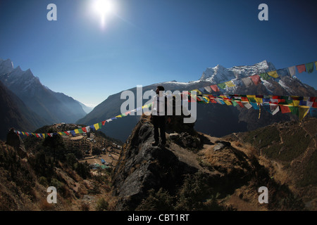 Der Mensch steht mit Gebetsfahnen in Namche Bazar mit Blick auf die Berge Stockfoto