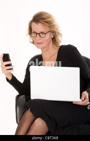 leitender Sekretär mit Laptop in der SMS-Versand Stockfoto