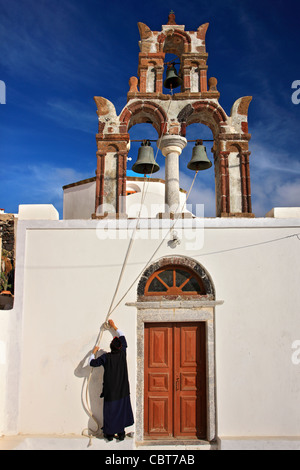 Griechisch-orthodoxe Priester bereit, die Glocken der Kirche im malerischen Dorf Pyrgos, Santorin, Kykladen, Griechenland Stockfoto