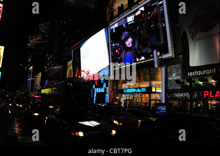 Nacht Neon elektrisches Licht schräg Schuss Scheinwerfer Verkehr vordere LED-Fassaden Disney, Forever 21 Läden, 7th Avenue, New York Stockfoto