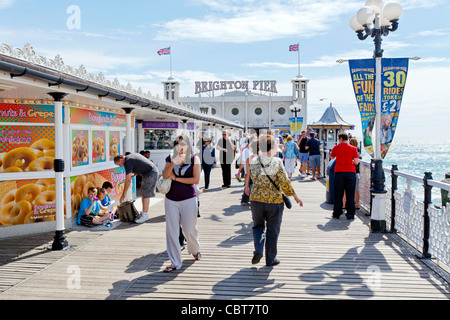 Menschen auf Urlaub und Ferien sitzen, entspannen, Wandern und Vergnügen sich auf der Pier von Brighton Promenade. Stockfoto