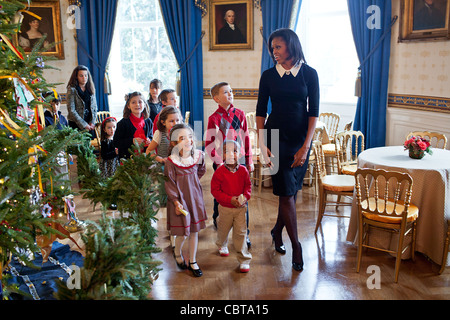 First Lady Michelle Obama geht mit Kindern vorbei an den offiziellen White House Weihnachtsbaum im blauen Zimmer 30. November 2011 in Washington, DC. Frau Obama begrüßt Soldaten und deren Angehörige ins Weiße Haus für für die Erstbesichtigung 2011 Urlaub Dekorationen. Stockfoto