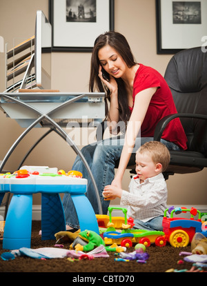 Kaukasische Frau kümmert sich Kind und Arbeit im home-office Stockfoto