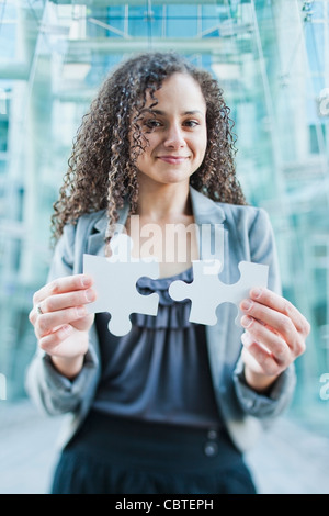 Kaukasische Geschäftsfrau hält Jigsaw Puzzle-Teile Stockfoto