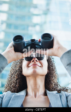 Kaukasische Geschäftsfrau Blick durch ein Fernglas Stockfoto