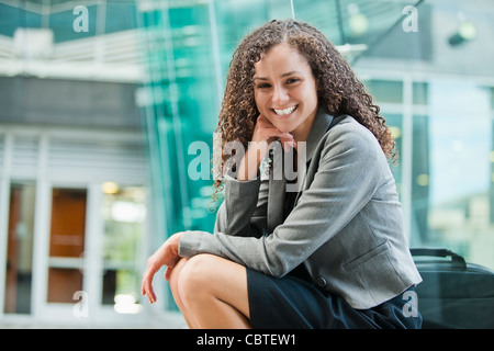 Lächelnd kaukasischen Geschäftsfrau im Freien sitzen Stockfoto