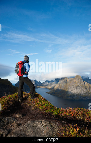 Weibliche Wanderer genießt Aussicht über Berge und Fjorde von Reinebringen, Lofoten Inseln, Norwegen Stockfoto