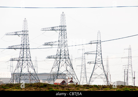 Fischer "kleine Häuser im Gegensatz zu Hochspannungsleitungen Nuclear Power Station, Dungeness, Kent, Großbritannien Stockfoto