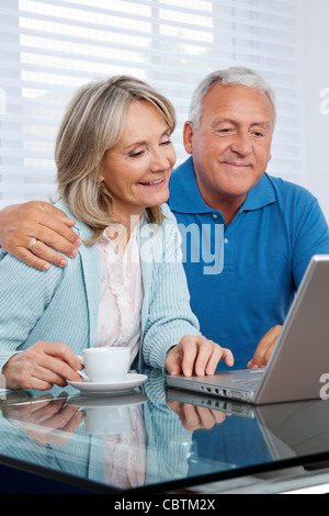 Glückliches Paar zusammen am Laptop Surfen Stockfoto