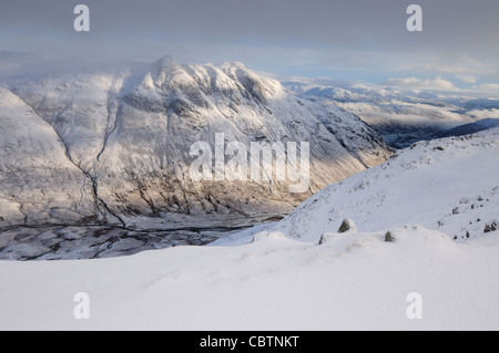 Brechen von Sonnenlicht auf die Langdale Pikes im Winter im englischen Lake District Stockfoto