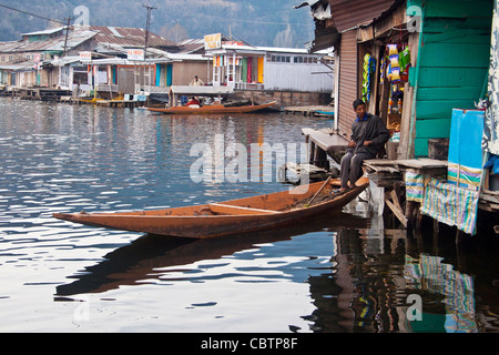 Ein Kashmiri Mann sitzt in seinem Shop auf dem schwimmenden Markt von Dal-See Stockfoto