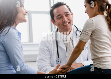 Arzt im Gespräch mit Mädchen und ihre Mutter im Untersuchungsraum Stockfoto