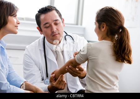 Arzt untersuchen Patienten während Mutter Uhren Stockfoto