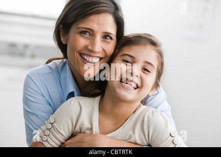 Lächelnde Mutter und Tochter umarmt Stockfoto