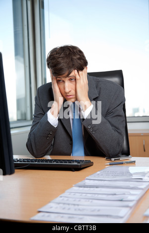 Gestresst Geschäftsmann sitzt an seinem Schreibtisch vor dem computer Stockfoto