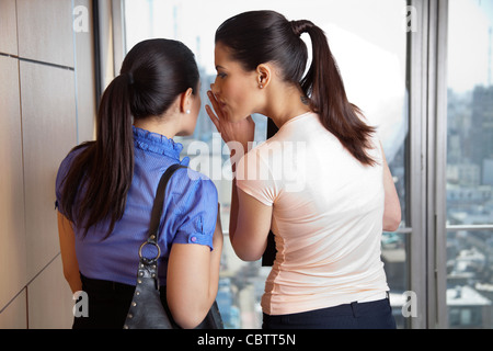 Zwei weibliche Mitarbeiter im Büro Flüstern Stockfoto