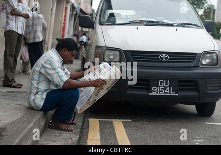 Ein Mann liest Zeitung, Little India, Singapur Stockfoto